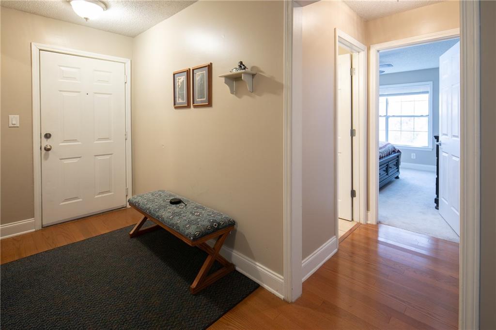 Hall featuring light carpet and a textured ceiling