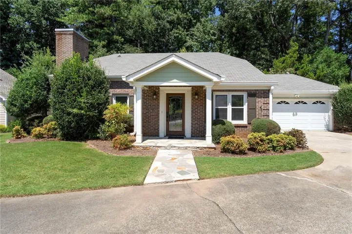 Brick exterior with a covered entry and stone pathway