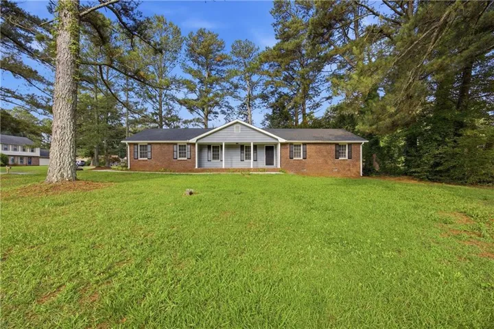 Brick and siding ranch-style exterior with a dark shingle roof