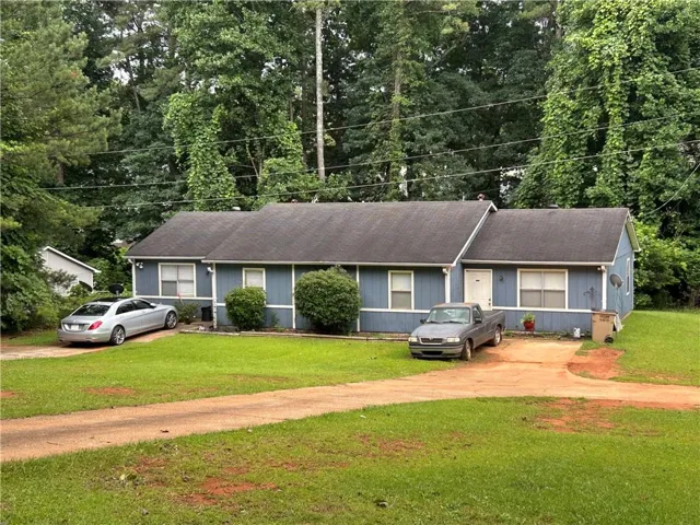 Blue exterior siding, asphalt shingle roof, white trim windows, white entry door, mature trees