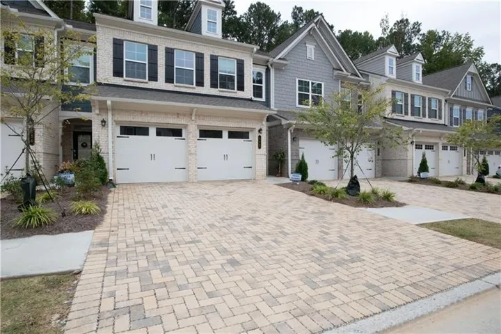 Brick and siding exterior featuring dormer windows, black shutters, and a covered entry