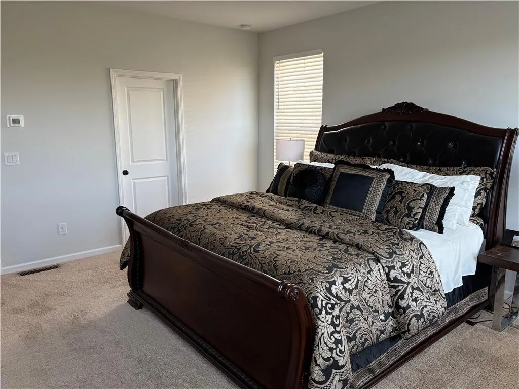 Neutral wall color, wall-to-wall carpeting, and a single-panel interior door