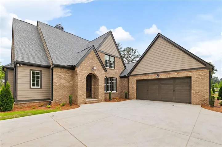 Brick and siding exterior featuring an arched entry