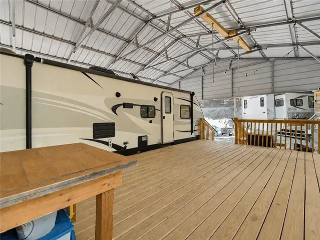 This expansive outdoor deck features wood-finish flooring, a metal awning, and plenty of room for outdoor merriment.