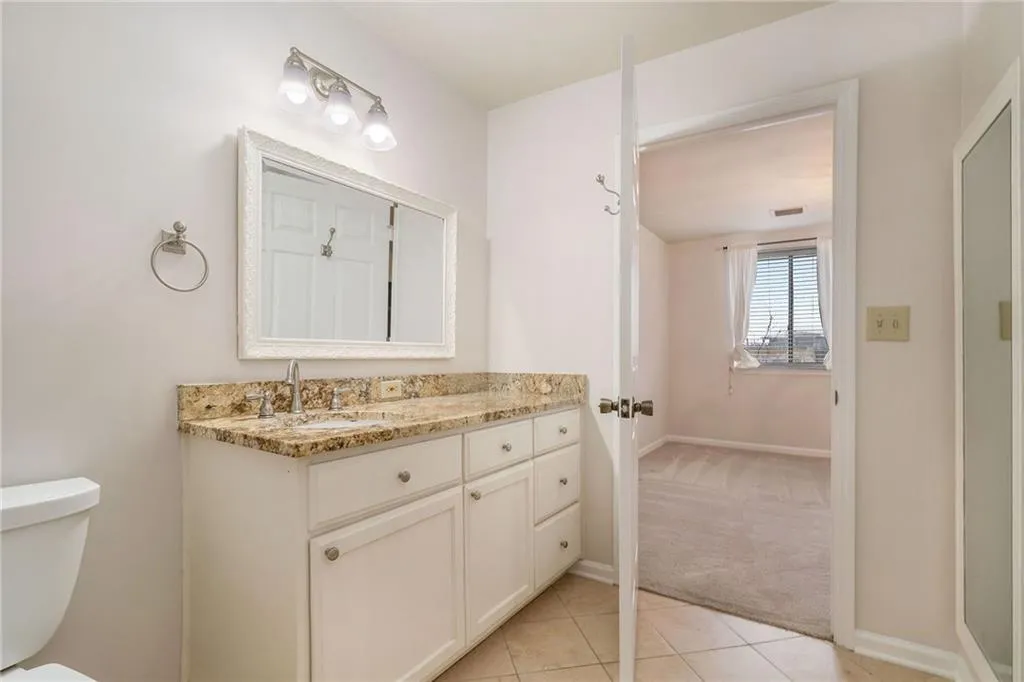 Bathroom featuring toilet, large vanity, and tile floors