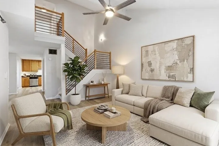 Virtually staged view of the living room with vaulted ceilings.