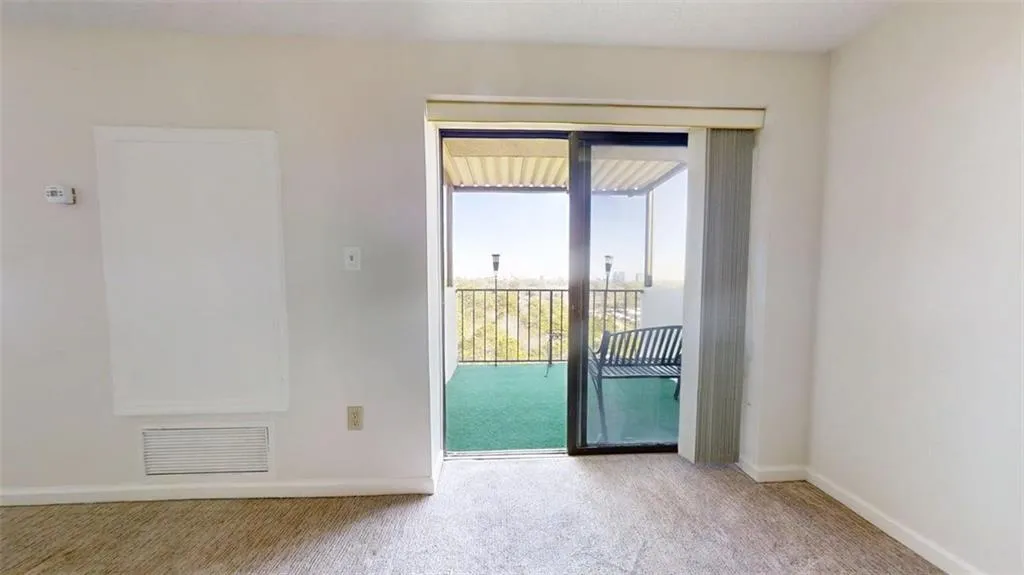 Spare room with baseboards and light carpet
