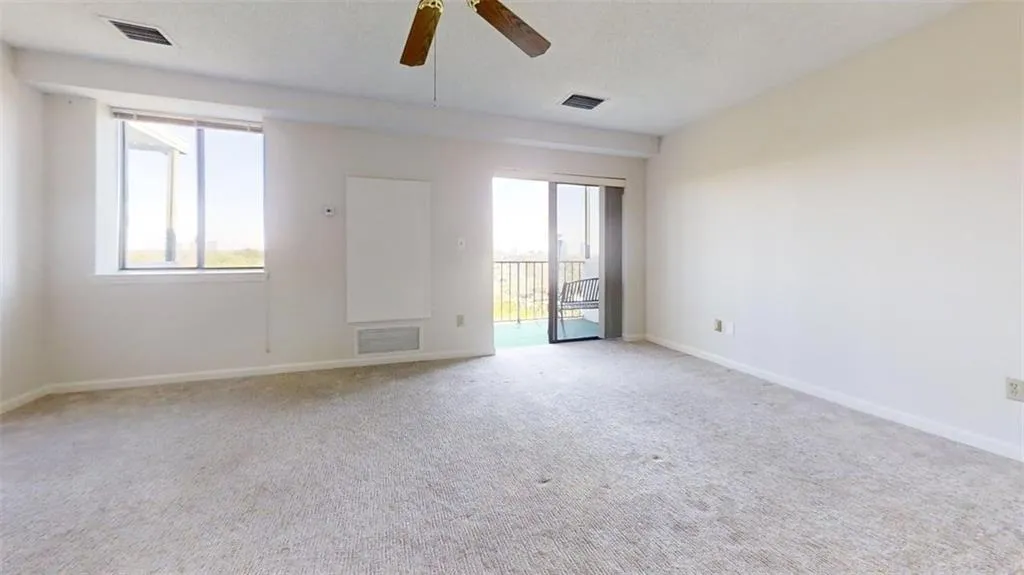 Empty room with a ceiling fan and carpet floors