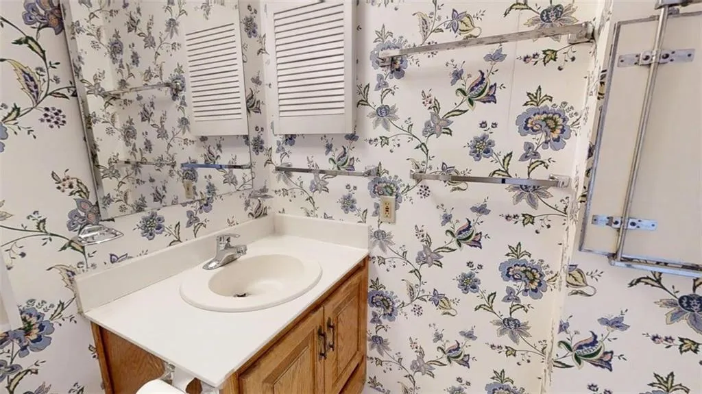 Bathroom featuring vanity and wallpapered walls