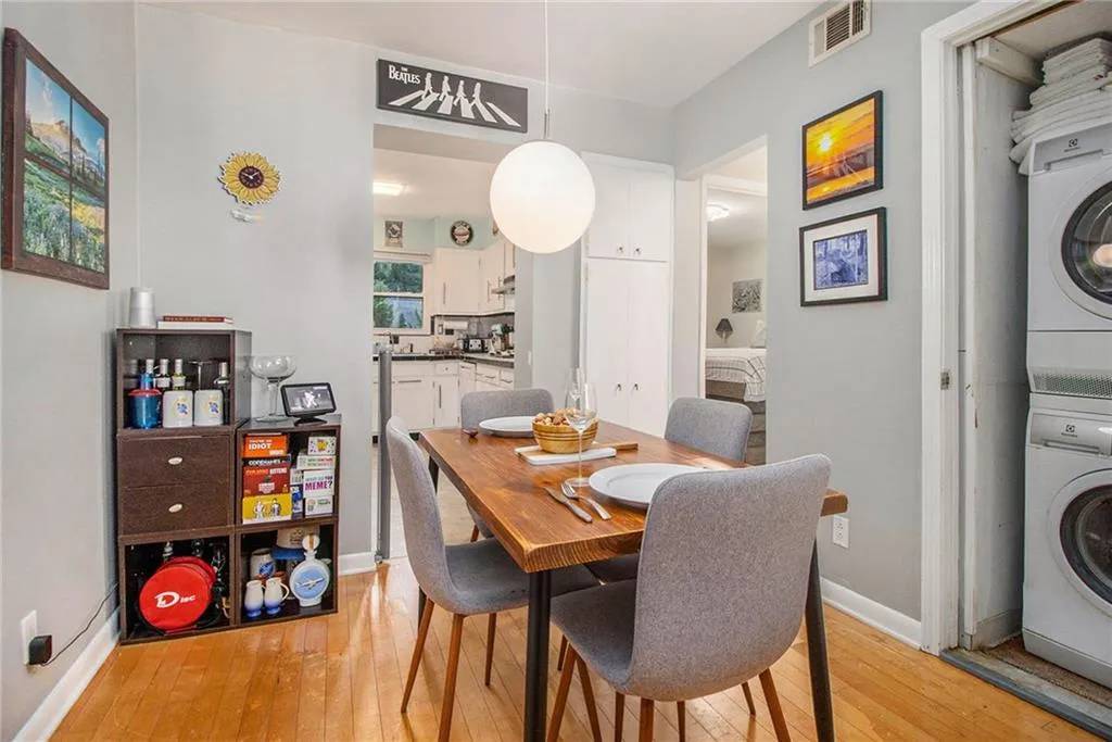 Dining area with light wood-style floors and stacked washing machine and dryer