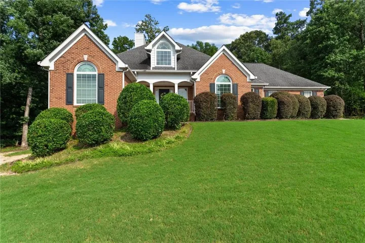 Traditional brick residence featuring a prominent gable roofline and dormer window