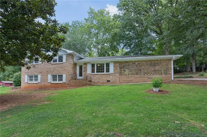 Brick exterior with white shutters and a decorative brick screen