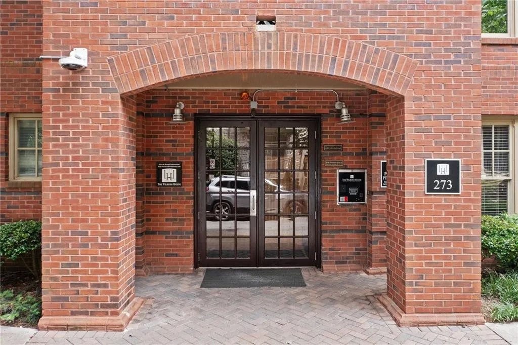 Property entrance featuring french doors and brick siding