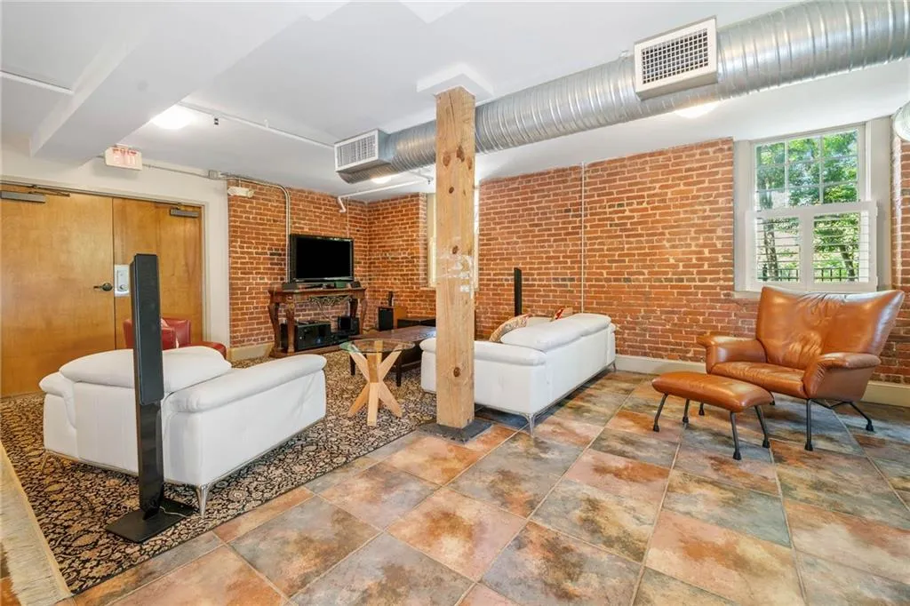Living area featuring brick wall and stone finish flooring