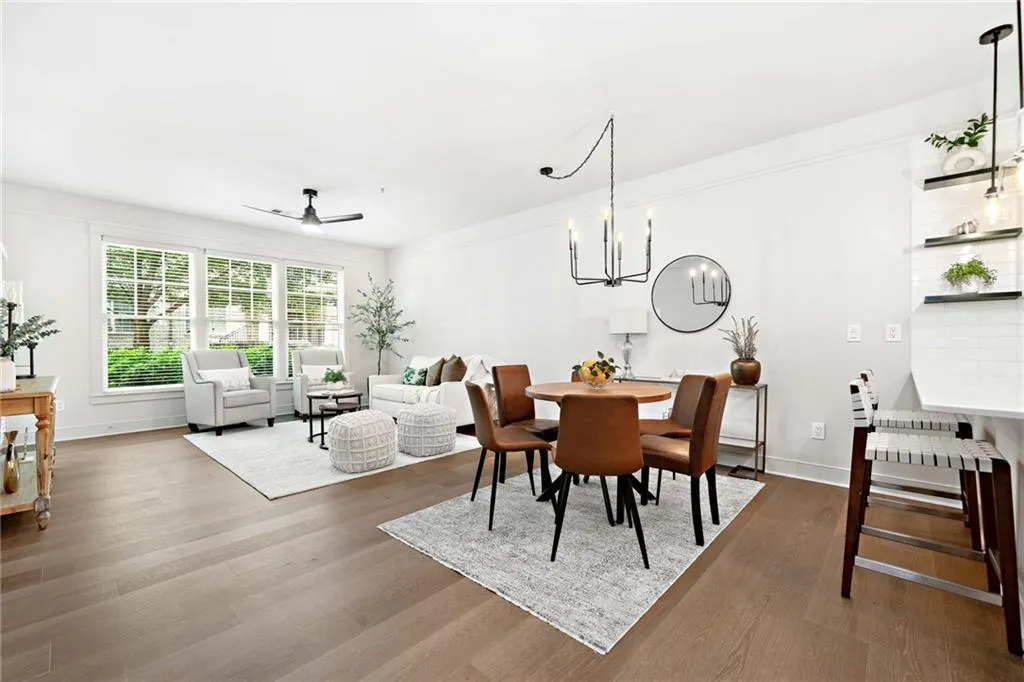 Dining room featuring ceiling fan, wood finished floors, a chandelier, and baseboards