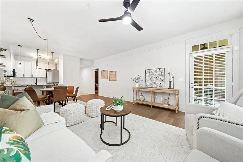 Living area with wood finished floors, ceiling fan, and baseboards