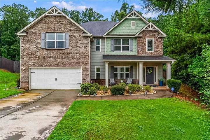 Two-story brick and siding exterior with peaked gable roofline and decorative cross bracing
