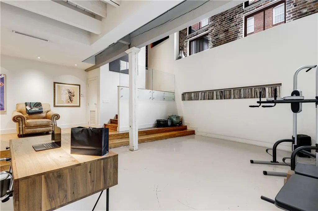 Workout area featuring baseboards and a high ceiling