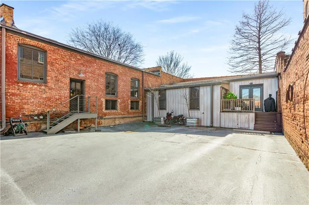 Back of property featuring brick siding, a patio, and a chimney