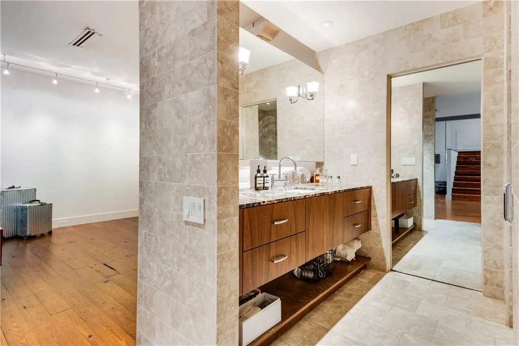 Bathroom with tile walls, vanity, and radiator