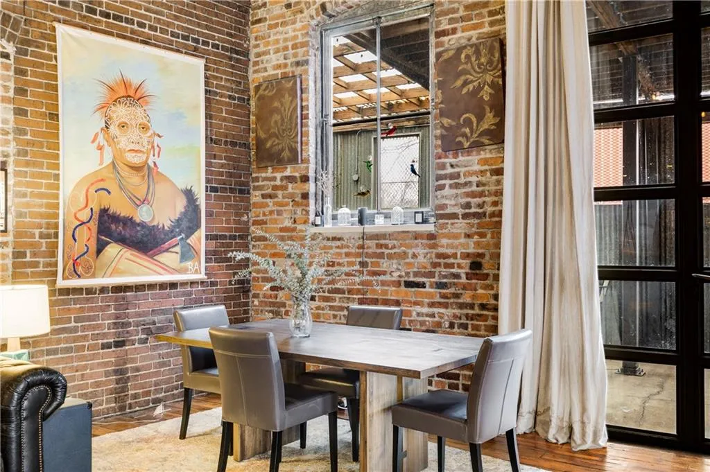 Dining room featuring brick wall and wood finished floors