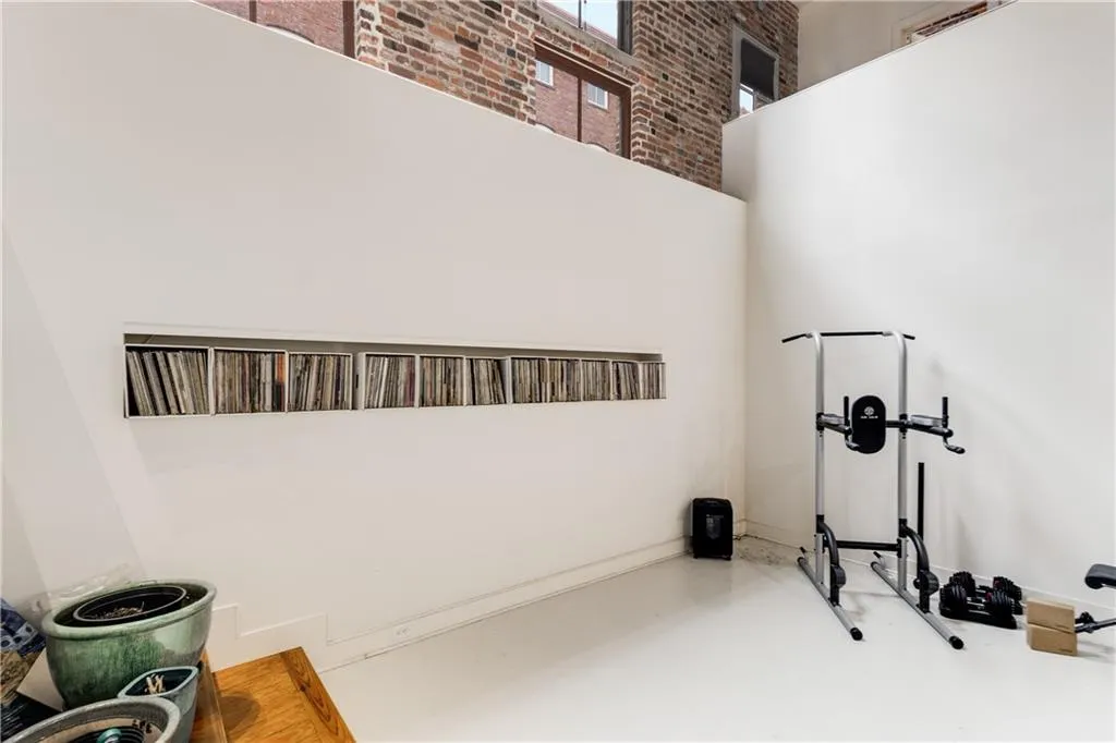 Workout area with a towering ceiling and brick wall