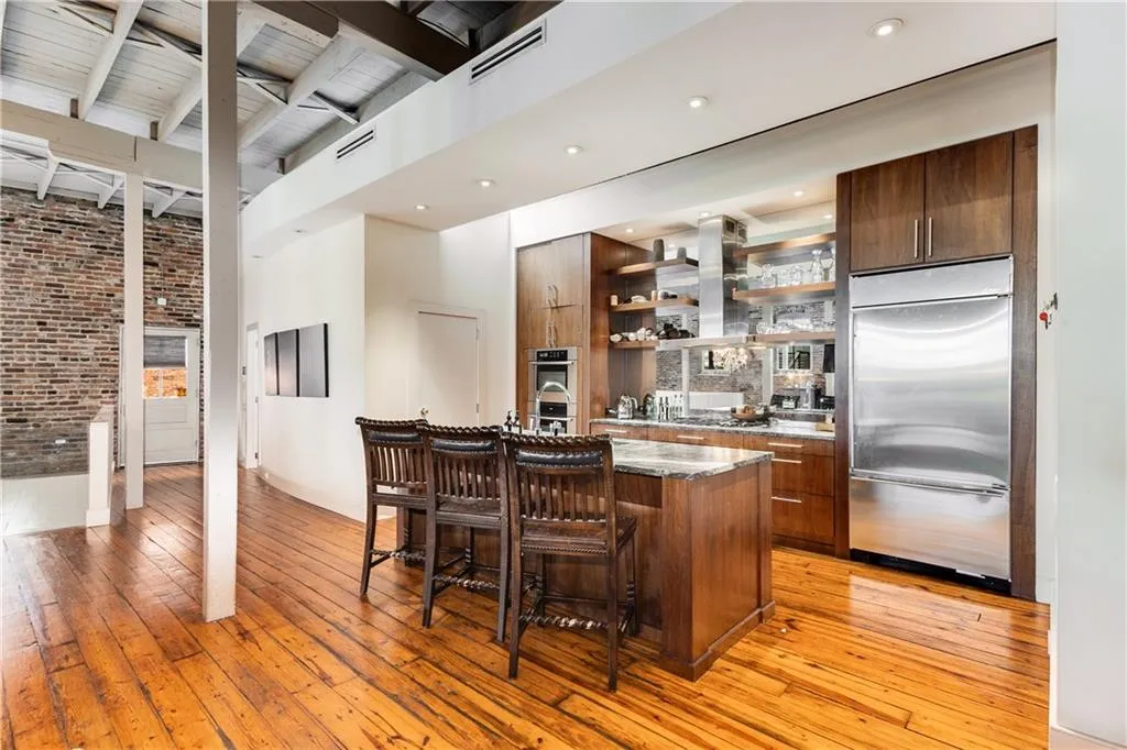 Bar area with appliances with stainless steel finishes, open shelves, dark stone counters, modern cabinets, and beamed ceiling