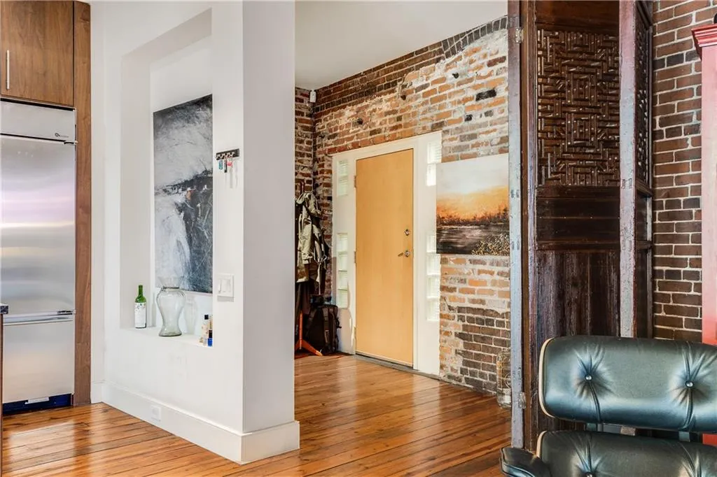 Corridor with brick wall and hardwood / wood-style floors