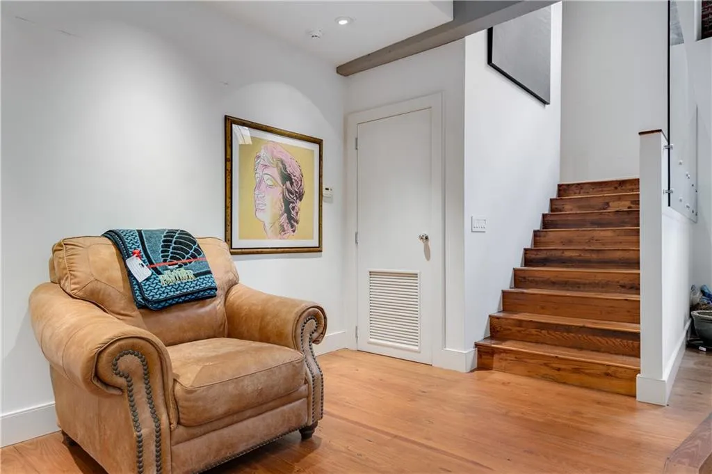 Sitting room with light wood finished floors and stairway