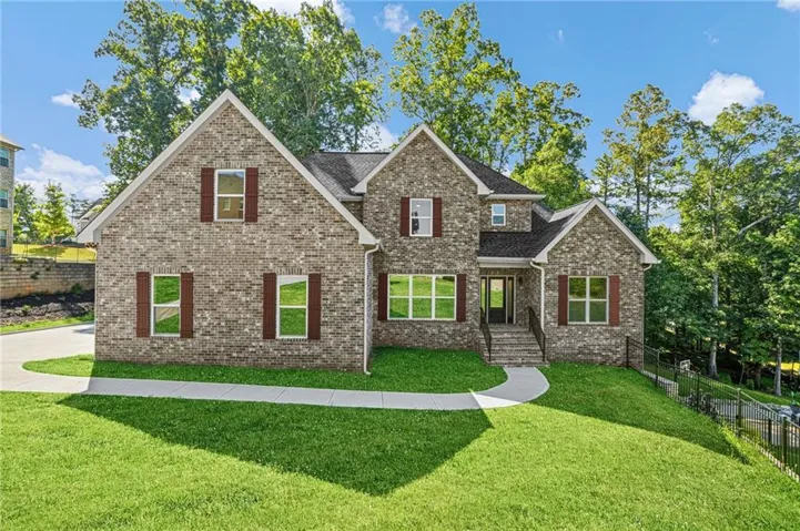 Brick exterior with dark shutters, gabled rooflines, and a concrete driveway