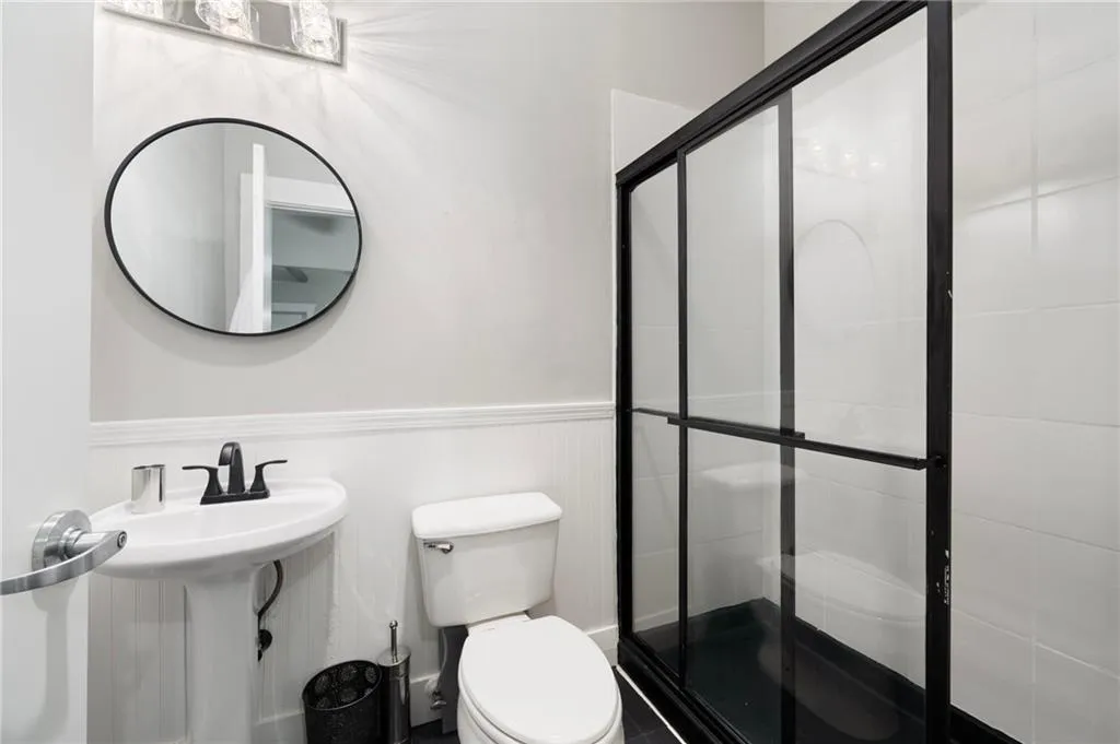 Bathroom with a shower stall and wainscoting