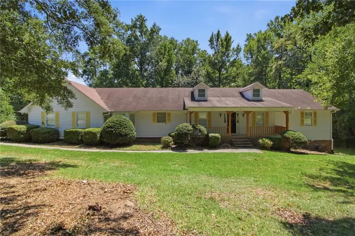 Charming single-story residence featuring a welcoming front facade with yellow exterior siding, dormer windows, and a covered front porch