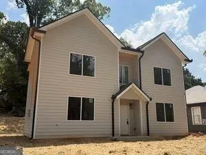 Two-story residence featuring light-toned horizontal siding, multiple gabled rooflines, and a covered entry porch