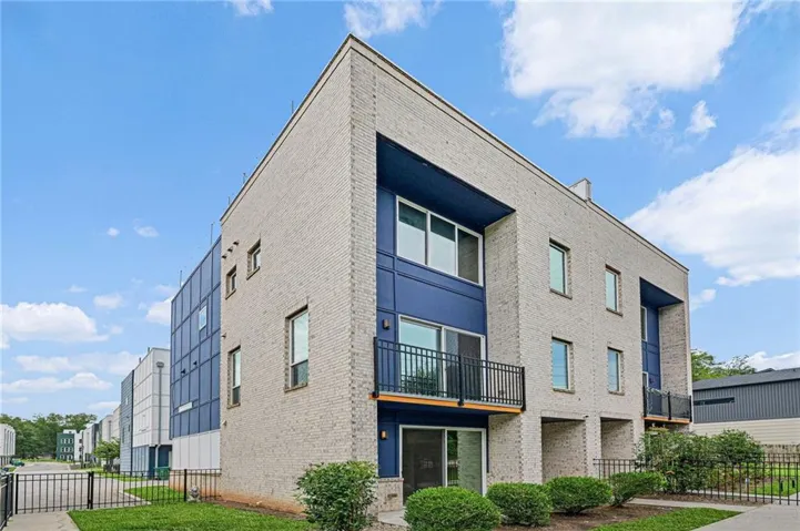 Three-story exterior featuring light-colored brick and dark blue paneling