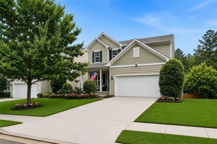 Two-story residence featuring light siding, dark shutters, and a covered front porch