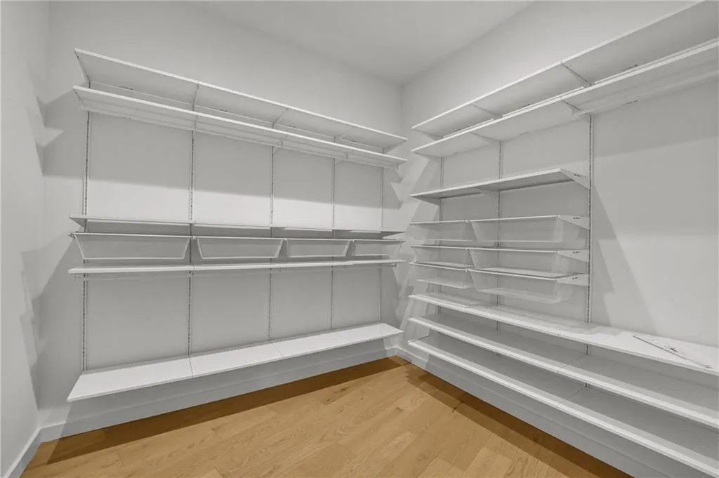 Custom adjustable shelving system featuring multiple storage tiers, built-in wire baskets, and wood-finish flooring