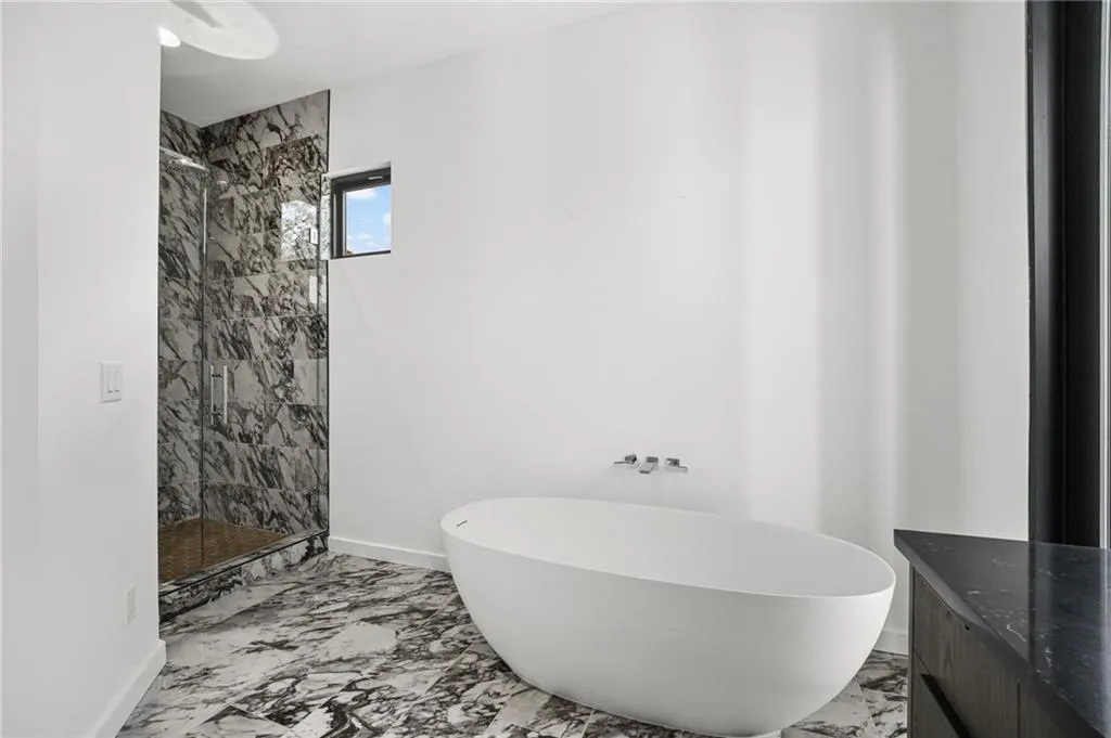 Freestanding soaking tub with wall-mounted fixtures