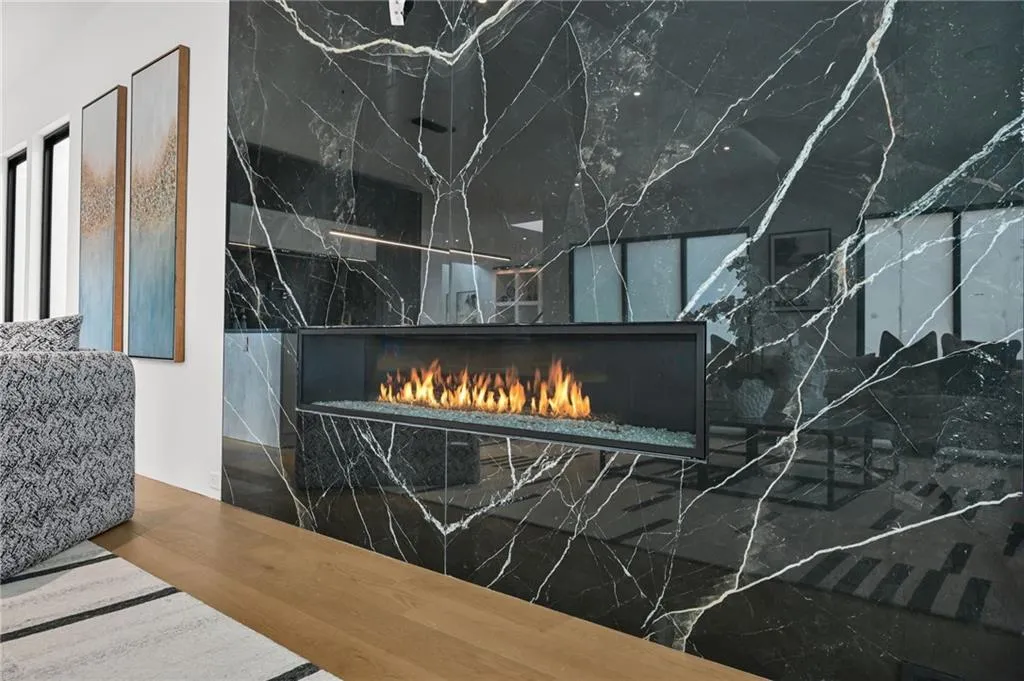 Sleek linear fireplace integrated into a dramatic large-format slab wall