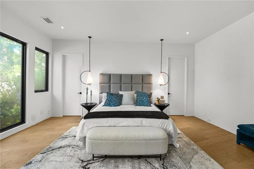 Wide plank wood-finish flooring, recessed lighting, and a paneled accent wall