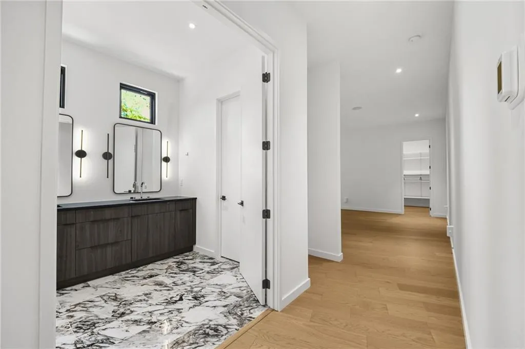 Custom double vanity with wood-finish cabinetry and dual framed mirrors