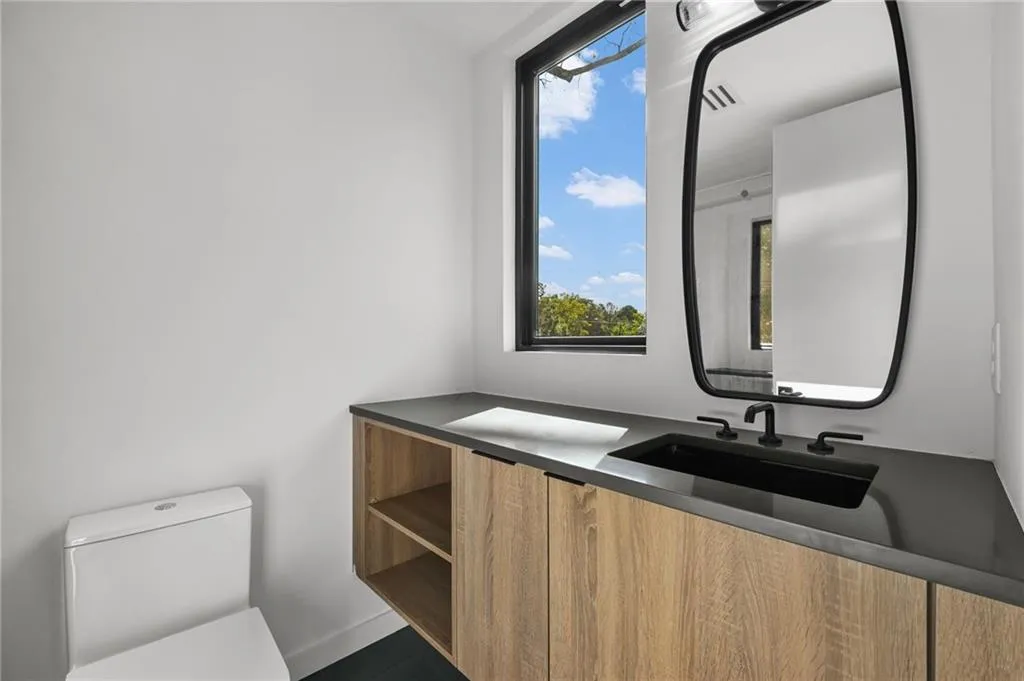 Floating wood-finish vanity with a dark countertop and integrated sink