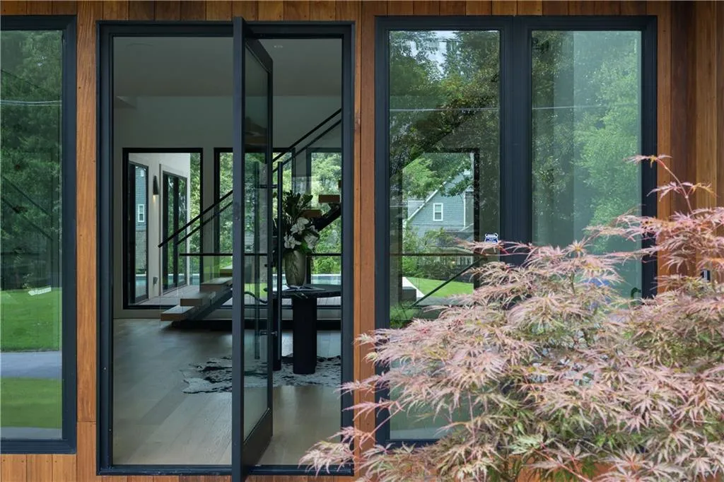 Wood-paneled exterior featuring large black-framed windows and a double entry door