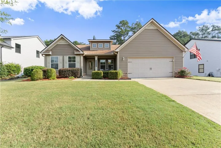 Single-story residence featuring a two-car garage, dormer window, and a covered entry porch