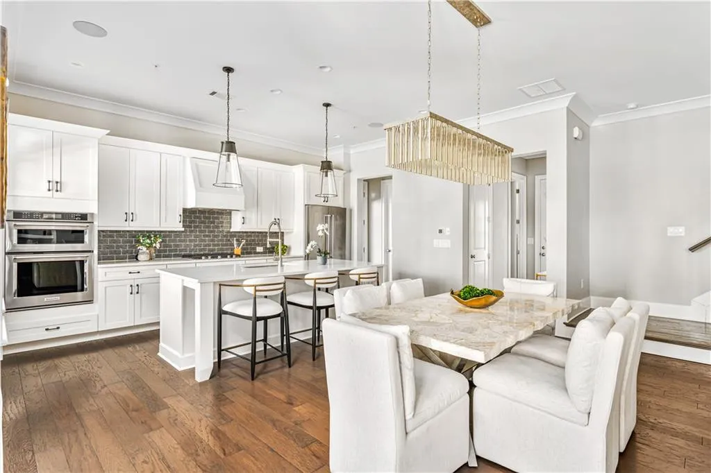 Dining area with dark wood-style floors, visible vents, stairs, and ornamental molding