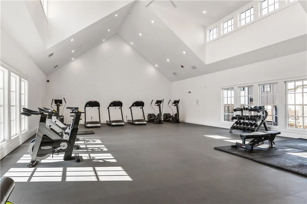 Exercise room featuring high vaulted ceiling, visible vents, and recessed lighting