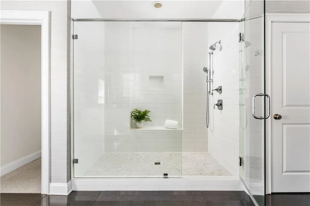 Full bathroom featuring a stall shower, baseboards, and tile patterned floors