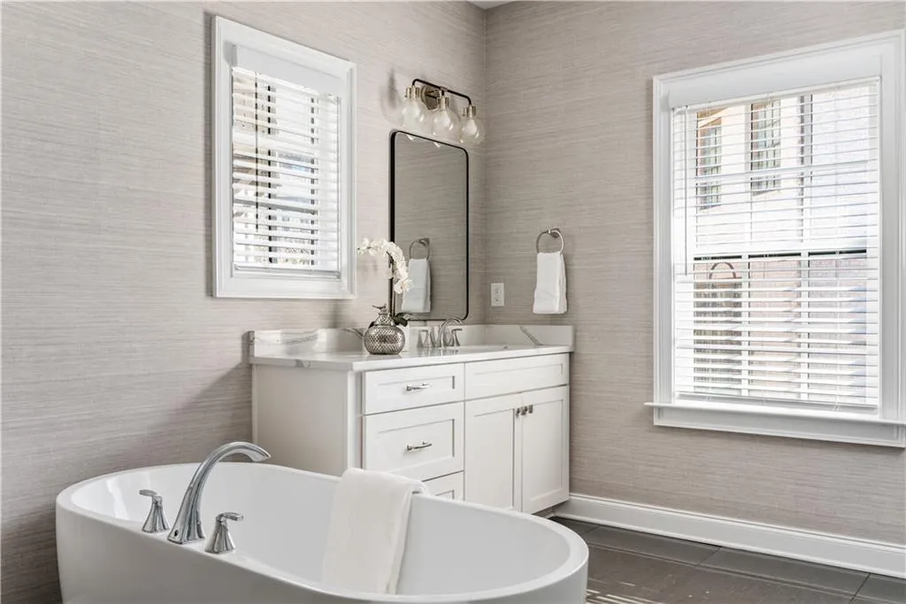 Bathroom featuring a freestanding tub, plenty of natural light, vanity, and tile patterned floors
