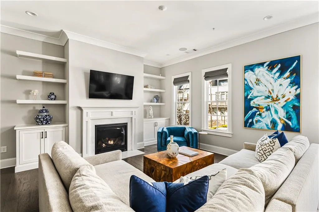 Living room featuring dark wood-style floors, crown molding, and baseboards