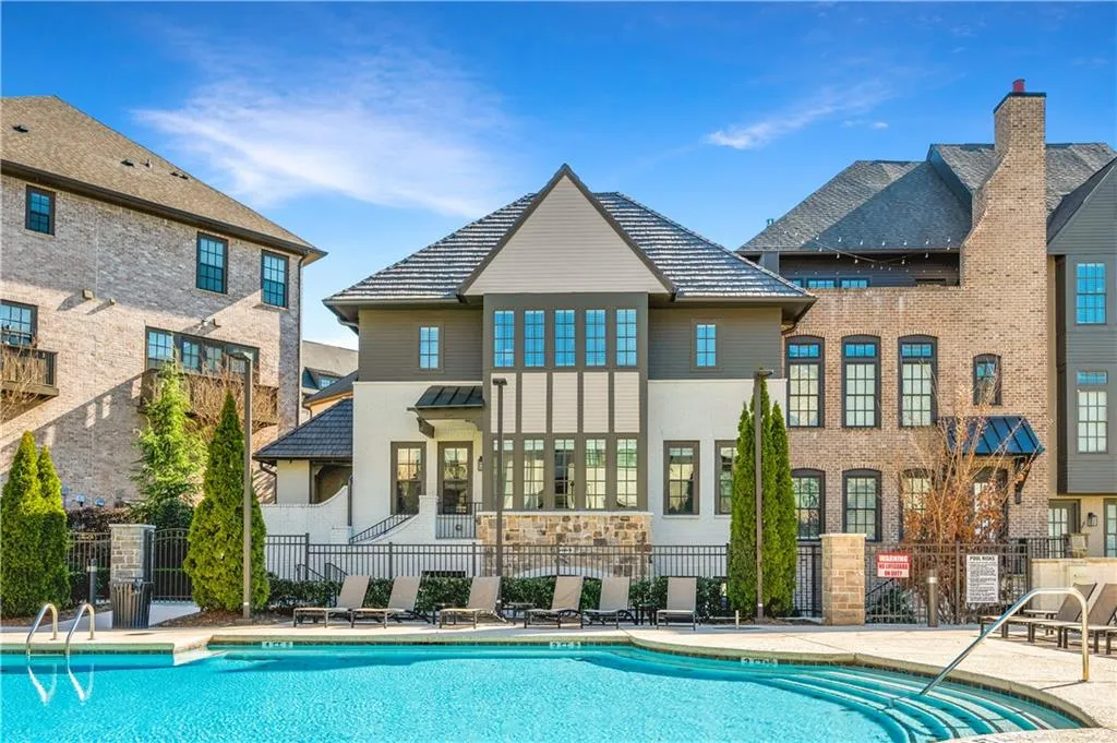 Rear view of house with a patio area, fence, and a community pool