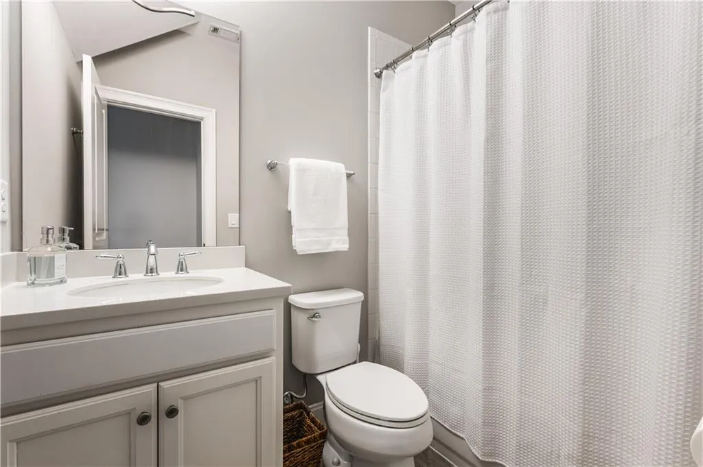 Bathroom featuring toilet, a shower with curtain, and vanity